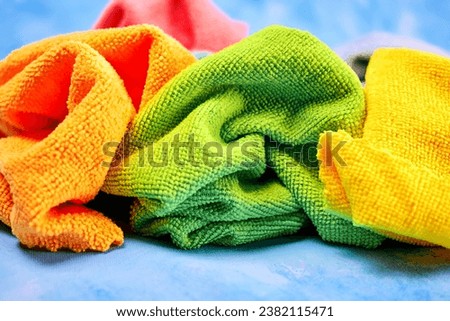 colored microfiber cloths chaotically crumpled lie together for cleaning and cleaning anything, on a blue background close-up Royalty-Free Stock Photo #2382115471