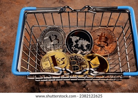 a consumer basket at the bottom of which there are coins of electronic cryptocurrencies Bitcoin, Ethereum, Litecoin, Ripple, as a concept for optat on the Internet Royalty-Free Stock Photo #2382122625
