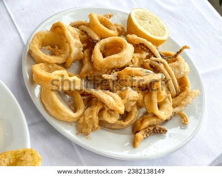 Fried calamari rings plate with lemon half on the side, Top view fried sea food picture