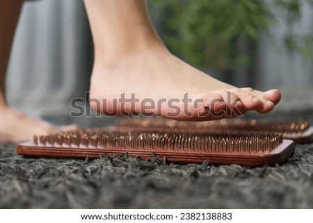 Woman's feet stand on a board with nails