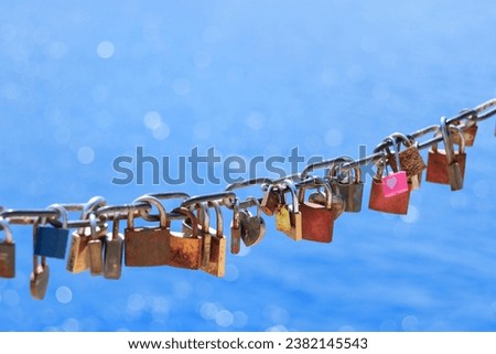 Love, romantic. Old rusty love locks on chain against background of blue sea on sunny day. Valentine day love symbol concept. Locked locks of love and loyalty. Greeting card 