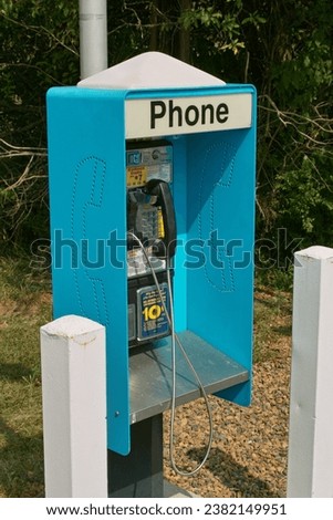 A close-up view of an old blue phone booth. Royalty-Free Stock Photo #2382149951