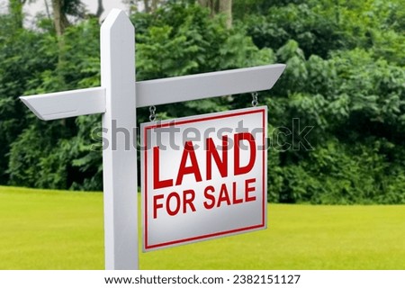 LAND FOR SALE SIGN on empty meadow - Real estate conceptual image
