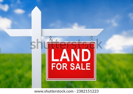 Beautiful green field and blue sky with LAND FOR SALE sign