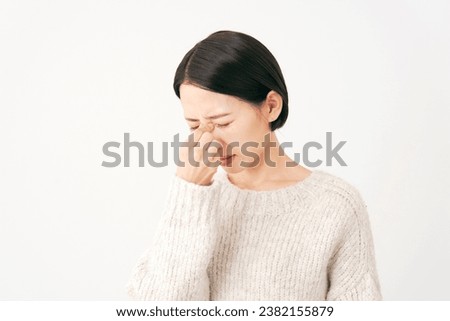 Asian middle aged woman with tired eyes in white background Royalty-Free Stock Photo #2382155879