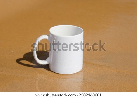 A white mug placed on a log with a view of nature in the background.