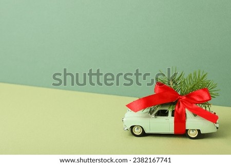 A green car with a Christmas tree and a red bow.