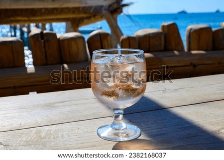 Summer party time in Provence, glass of rose wine with ice cubes on bar terrace Pampelonne sandy beach near Saint-Tropez in sunny day, Var department, France