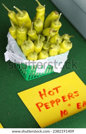 Hot peppers 10 ten cents each. Yellow. Farm fresh produce. Small local market stand. Signage. Retail. Buy local. Agriculture. Crop. Farming. Harvest. Seasonal. Summer. 