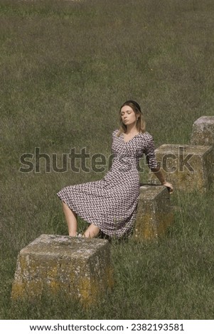 Serie of photos of female model in viscose midi dress posing on meadow. Outdoor portrait with natural light.