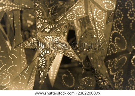 Colorful yellow xmas lantern stars at christmas market season. Beautiful shiny star mood lamp in merry advent decoration. Traditional symbol of the best miracle time of the year. Part of series
