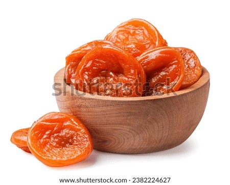 Dried apricots in a wooden plate and scattered close-up on a white background. Isolated Royalty-Free Stock Photo #2382224627