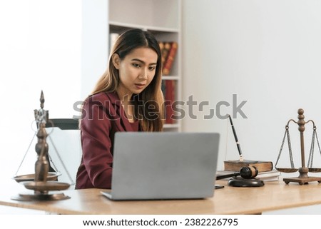 Young Asian female lawyer people reviewing legal documents at desk, embodying reliability, dedication in legal profession, reading announcement. Court convicting defendant according to criminal law