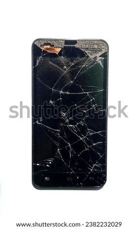 black cellphone with a broken and cracked screen on a white background