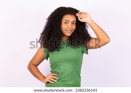 Beauty portrait of an afro girl with clean healthy skin on white background. Beautiful and dreamy black woman smiling. Afro style curly hair