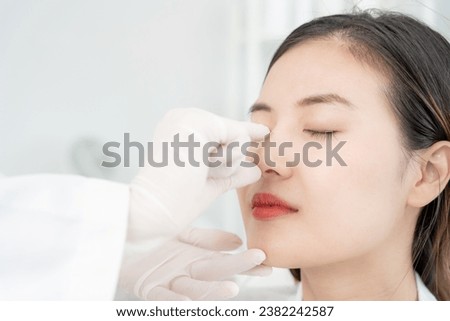 plastic surgery, beauty, Surgeon or beautician touching woman face, surgical procedure that involve altering shape of nose, doctor examines patient nose before rhinoplasty, medical assistance, health Royalty-Free Stock Photo #2382242587