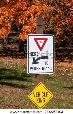 Yield to pedestrian sign in a park during autumn 
