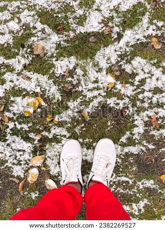 Legs in white sneakers on, low angle view, copy space, Hello spring, Goodbye winter concept. Vertical photo