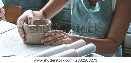 Potter makes dishes from clay, ceramics.Craft,work by hand in the workshop.Do it yourself products from ceramics.Close up of human hands making a clay bowl. Pottery teaching class Royalty-Free Stock Photo #2382283271