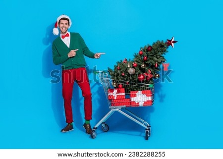 Full length photo of funny cute man wear x-mas green cardigan pointing fingers bargains buyer isolated blue color background
