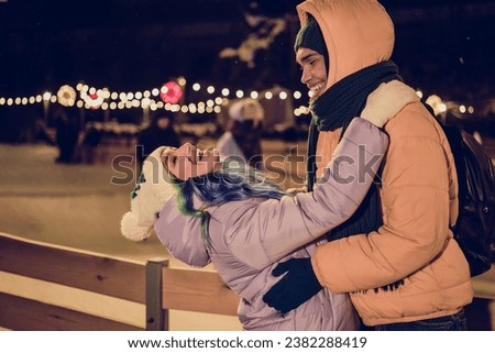 Photo of funny funky american guy lady wear windbreakers hugging dancing celebrating xmas time together outside urban market park