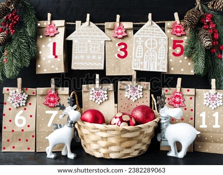 Original Christmas advent calendar as a countdown to Christmas Eve on a wooden background.  New Year and Christmas holidays concept.  Gifts and New Year's decorations, New Year's toys.  Front view.