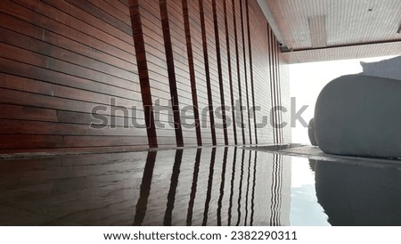 Image of building with wooden wall reflect by water on the floor