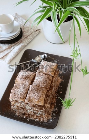 Delicious millefeuille dessert with chocolate cream isolated on white background. Overhead view. Copy space.