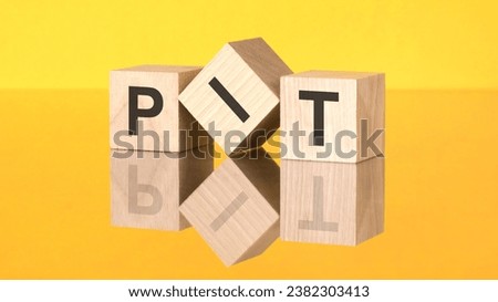 wooden cubes with text PIT on yellow background. Personal Income Tax concept
