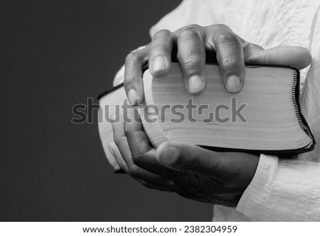 man praying to god with hands on bible together with black gray background with people stock image stock photo