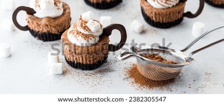 A narrow view of hot cocoa mini cheesecakes dusted with powdered cocoa. Royalty-Free Stock Photo #2382305547