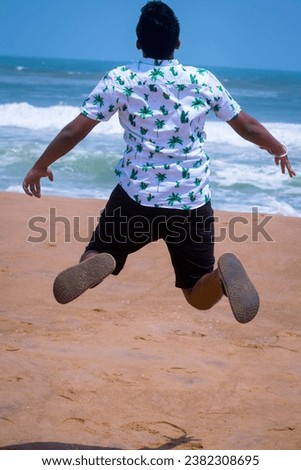 selective focus picture of a boy jumping at the beach 