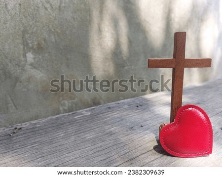 Jesus cross, red heart on wooden plank with leaf shadow  on cement wall as background. Jesus love you. Jesus die for you. Faith hope Believe salvation  Christianity concept