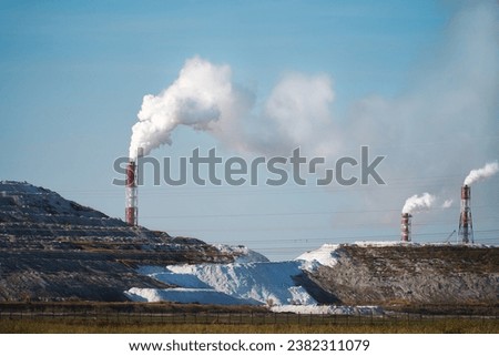 Smoky chimneys against the background of white slag heaps formed by the production of chemical fertilizers and feed phosphates.                               