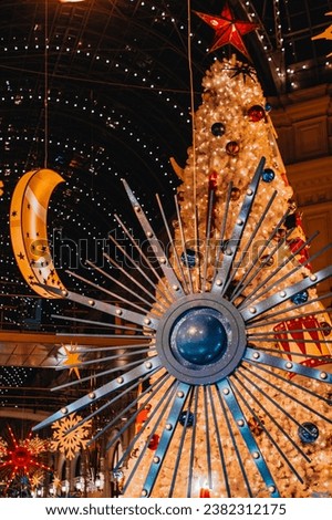 Golden Christmas tree, winter snowflakes and garlands hanging in the historic Russian shopping mall GUM. Christmas fairy tale, New Year atmosphere