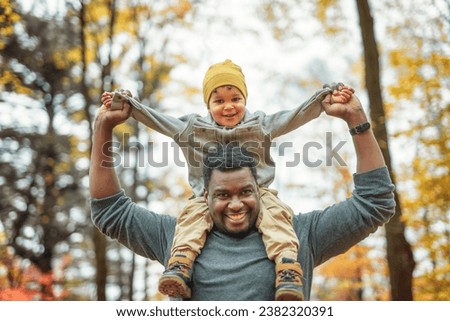 A father and son having fun in autumn park