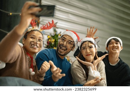 Party of asian Friends Enjoying Christmas Drinks and celebrating having selfie by smartphone. happiness women and man christmas eve celebrate dinner with food and beverage.
