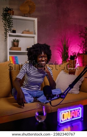 Portrait of an african american radio presenter looking into the camera while working in studio and recording an internet podcast episode. Live stream concept.