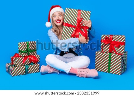 Full body photo of excited rejoice smiling young blonde girl hug holding brand new gifts happy new year isolated on blue color background