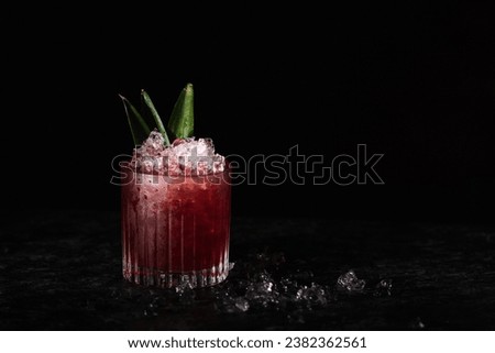 Black Currant Cocktail, with Pineapple slices and leaves for garnish. Crushed ice, black background and copy paste space Royalty-Free Stock Photo #2382362561