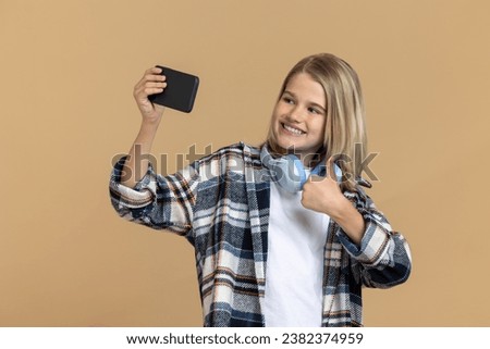 Smiling teen girl making selfie and looking enjoyed