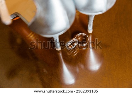 Silvery heels and gleaming rings reflect on rich wood, encapsulating moments of love and eternal commitment.