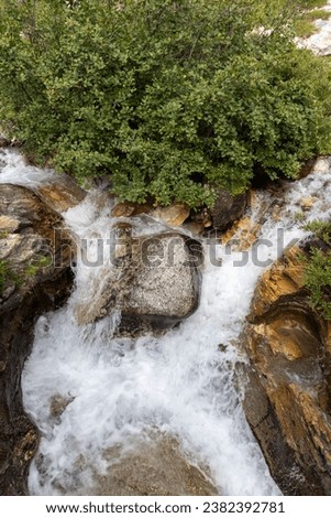 Mountain stream flows through a green valley in the Wallis Zwisterland summer 2023 