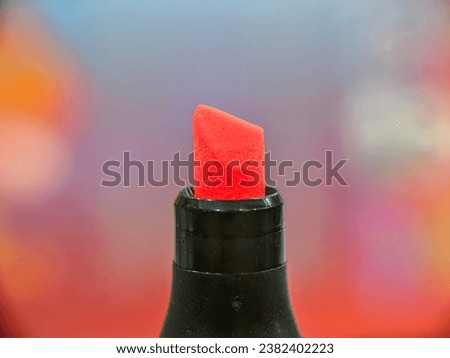macro of orange highlighter tip with black plastic and blured background