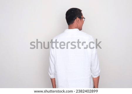 Rear view of a man standing and looking to the right direction Royalty-Free Stock Photo #2382402899
