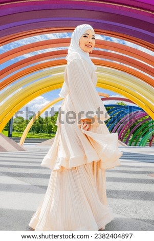 Muslim Asian women wear hijab and dress with light cream color at outdoor park.