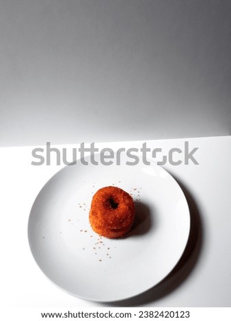 closeup of two sweet and soft palm sugar donuts stacked on a white plate isolated on white background.