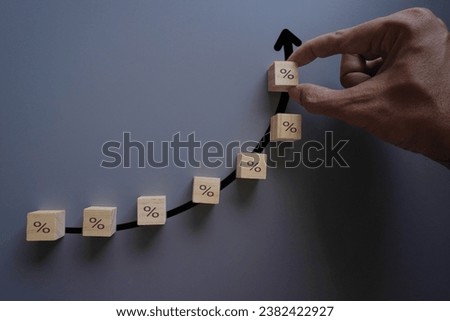 Hand arrange wooden cube with percentage icon. Increasing interest rate concept. 