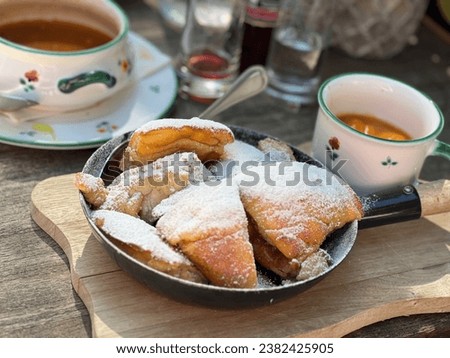 Typical Austrian dessert souffle ('Kaiserschmarren') with plum sauce and sugar dusting on a blue plate