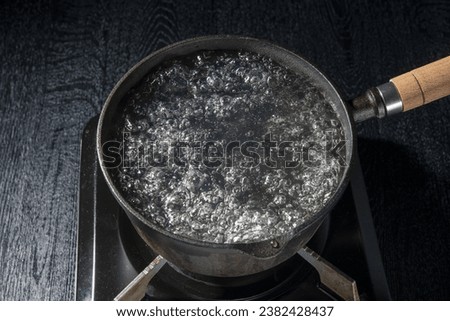 Boil water in an iron pot Royalty-Free Stock Photo #2382428437